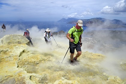 Italie, Sicile, iles Eoliennes, classées Patrimoine Mondial de l'UNESCO, ile de Vulcano, randonneurs dans l'ascension du cratère du volcan della Fossa à travers les fumerolles soufrées, l'Ile de Lipari puis Ile de Salina en arrière plan