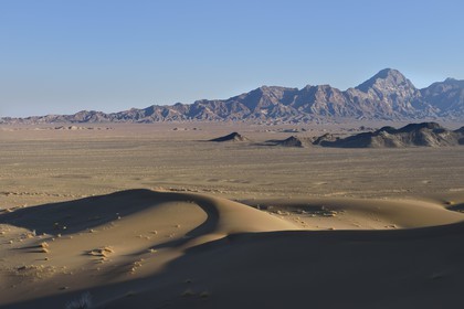 Iran, Province de Yazd, désert du Dasht-e Kavir, Moghestan, le massif montagneux de Moghestan face aux dunes dont la plus haute atteint les 200 mètres