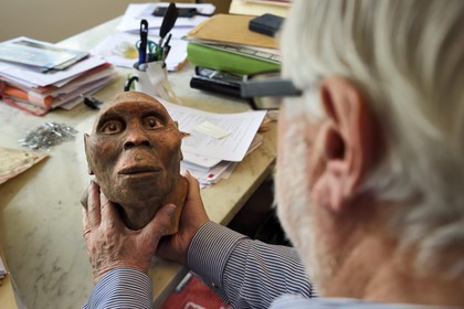 France, Paris, the french paleontologist and paleoanthropologist Yves Coppens, professor at the College de France, in the office of his home in Paris, he holds in his hand the supposed reproduction of Lucy's face
