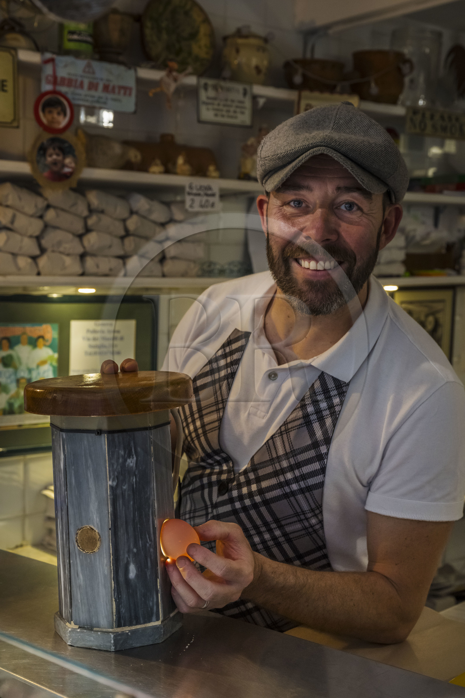 Italie, Ligurie, Gênes, ruelle du vieux centre historique, Sergio dans le magasin de volaille La Polleria dans la rue Vico Inferiore del Ferro, il s'amuse à présenter le miroir à oeufs de ses aieuls qui permettait d'en controler la fraicheur