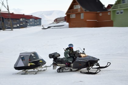 Norvège, Svalbard, Spitzberg, Longyearbyen, motoneige avec les enfants dans la remorque fermée