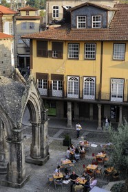 Portugal, région du Minho, Guimaraes, ville classée Patrimoine Mondial de l' UNESCO, belvedere gothique devant l'Eglise de Nossa Senhora Da Oliveira sur la place Largo da Oliveira et terrasse de café