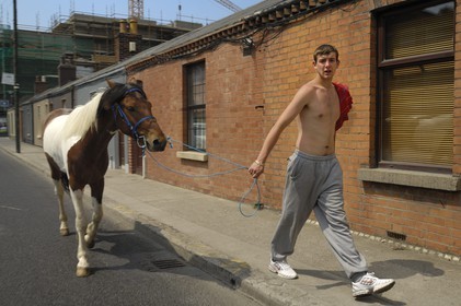 Republic of Ireland, County Dublin, Dublin, man in a street of the suburbs with his horse