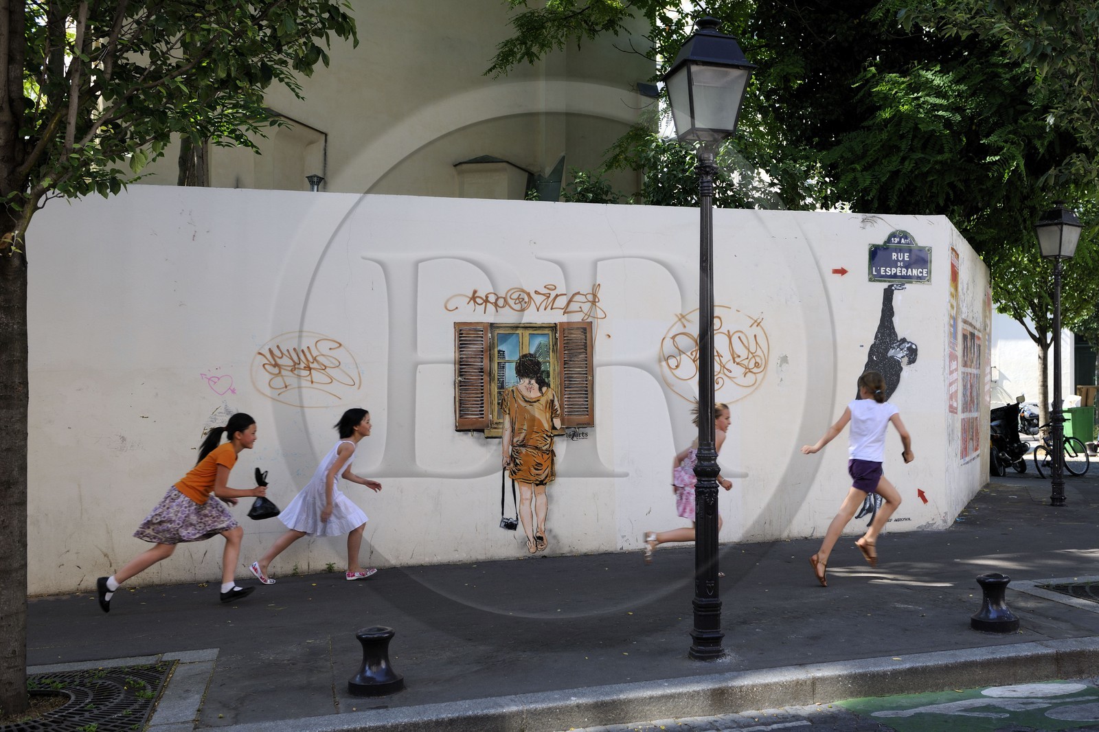 France, Paris (75), quartier de la Butte-aux-Cailles, enfants courant rue de l'Espérance sous un graffity de Lézards