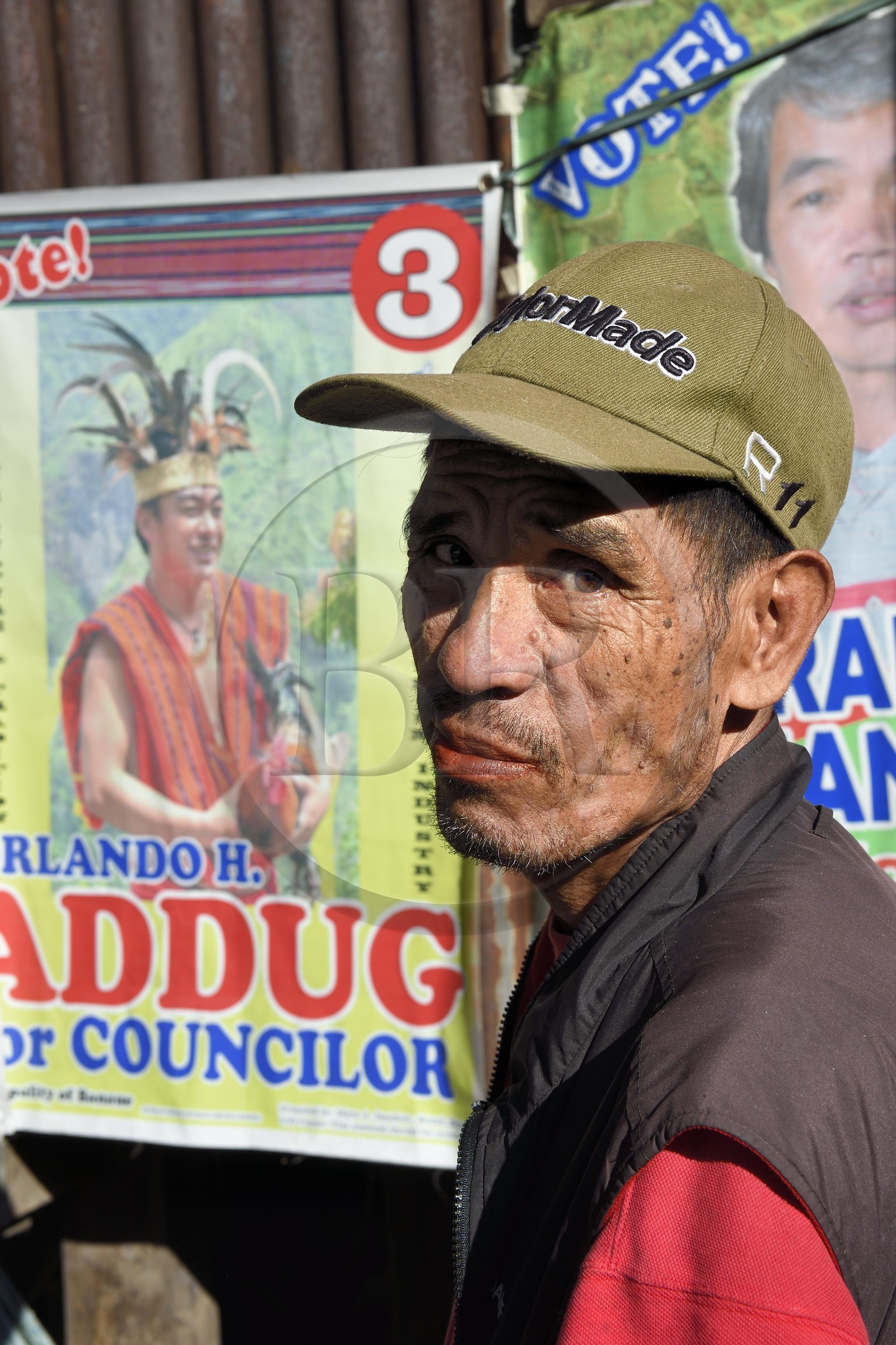 Philippines, province d'Ifugao, région de Banaue, village de Cambulo, un homme Ifugao devant un poster d'un candidat aux élections de conseiller en costume traditionnel