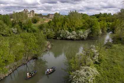 France, Vendée (85), Parc Interrégional du Marais Poitevin labellisé Grand Site de France, Maillezais, batelier effectuant une promenade en barque sur les affluents de l'Autise, les vestiges de l'abbaye Saint-Pierre de Maillezais en arrière plan (vue aérienne)