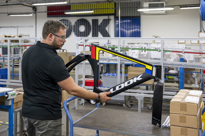France, Nièvre (58), Nevers, entreprise Look Cycles International, le technicien site évenementiel Thomas Millot brandit le cadre du vélo de compétition en carbone ultra-léger LOOK P24 qui a permis à Benjamin Thomas de gagner la médaille d'or aux JO de Paris 2024