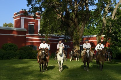 Argentine, province de Buenos Aires, San Antonio de Areco, groupe de gauchos à cheval devant l'estancia La Bamba de Areco