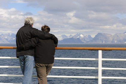 Groenland, région méridionale, couple observant la côte au large du Cap Farvel (Farewell) à bord du bateau de croisière le Princess Danané