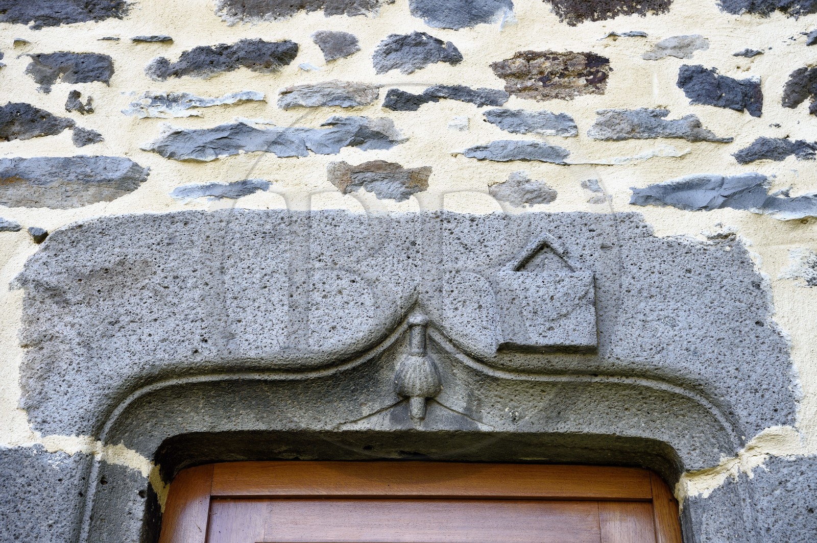 France, Cantal (15), Joursac, linteau sculpté de la maison d'un homme qui a fait le pélérinage de Saint-Jacques de Compostelle, on reconnait le haut du bourdon recouvert d'une coquille et la besace qui en sont des symboles