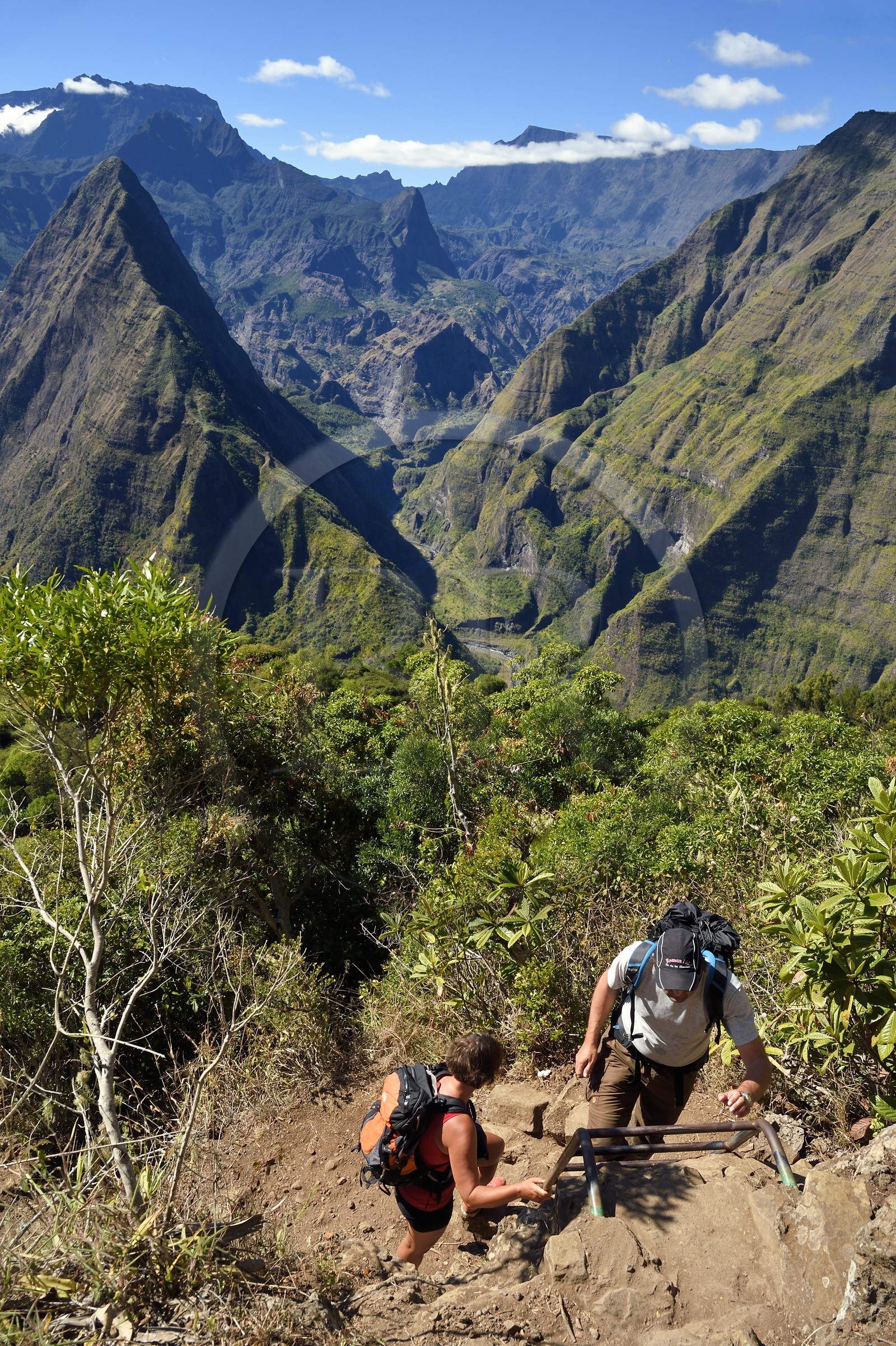 France, Ile de la Reunion, Parc National de la Réunion classé Patrimoine Mondial de l'UNESCO, La Possession, vers le village de Dos d'Ane, randonnée de la Roche Bouteille, randonneurs sur une échelle du sentier Cap Noir et le Cirque de Mafate