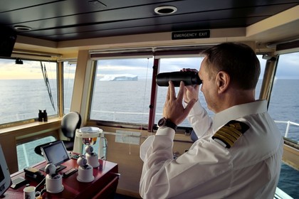 Greenland, North West coast, Baffin Bay, Captain Raymond Martinsen of Hurtigruten's MS Fram cruise ship observes icebergs with binoculars