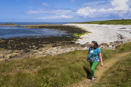 France, Finistère (29), Mer d'Iroise, Ile de Molène, Christine Demeure qui gère la seule épicerie de l'ile lors de sa promenade quotidienne sur la côte sauvage à l'Ouest, la grève du Roelen