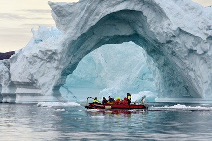 Groenland, cote Nord-Ouest, mer de Baffin, Inglefield Fjord vers Qaanaaq, iceberg formant un arche et un PolarCirkel boat (zodiac) d'exploration du bateau de croisière MS Fram de la compagnie Hurtigruten