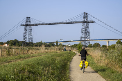 France, Charente Maritime, Rochefort, the Rochefort (or Martrou) transporter bridge built by Ferdinand Arnodin in 1900, cyclist along the cycle route