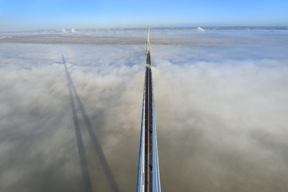 France, entre Calvados (14) et Seine-Maritime (76), le Pont de Normandie enjambe la Seine et émerge d'une mer de nuages, la Réserve Naturelle de l'estuaire de la Seine en arrière plan