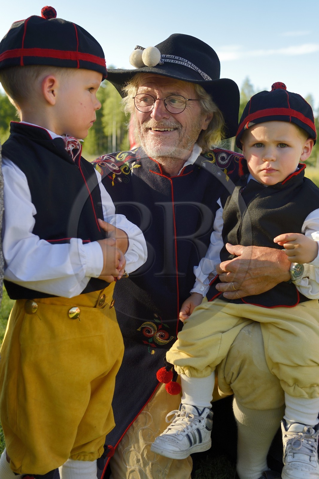 Suède, comté de Dalécarlie, région de Leksand, célébrations du solstice d'été dans le petit hameau de Hjulbäck, homme et ses petits enfants en costume traditionnel