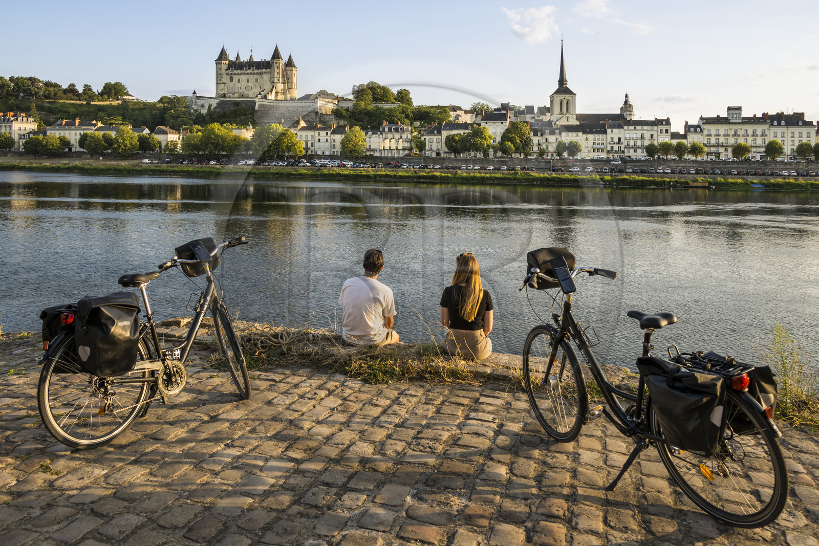 France, Maine-et-Loire, Loire valley listed as World Heritage by UNESCO, Saumur, cycling on the banks of the Loire, the castle and the church of Saint-Pierre on the banks of the Loire river