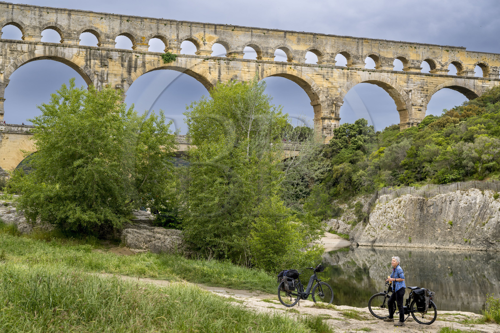 France, Gard (30), le Pont du Gard classé Patrimoine Mondial de l'UNESCO, Grand Site de France, cycliste prenant une pause devant le pont aqueduc romain qui enjambe le Gardon