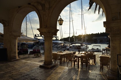 Croatie, Dalmatie, cote dalmate, Ile de Hvar, tables de restaurant sur les  quais de la ville de Hvar