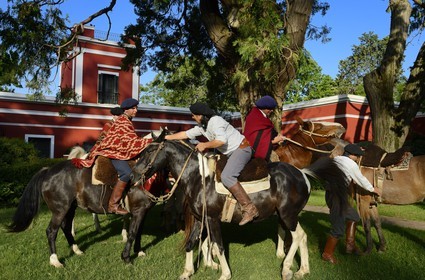 Argentina, Buenos Aires Province, San Antonio de Areco, group of gauchos on horseback in front of the estancia La Bamba de Areco