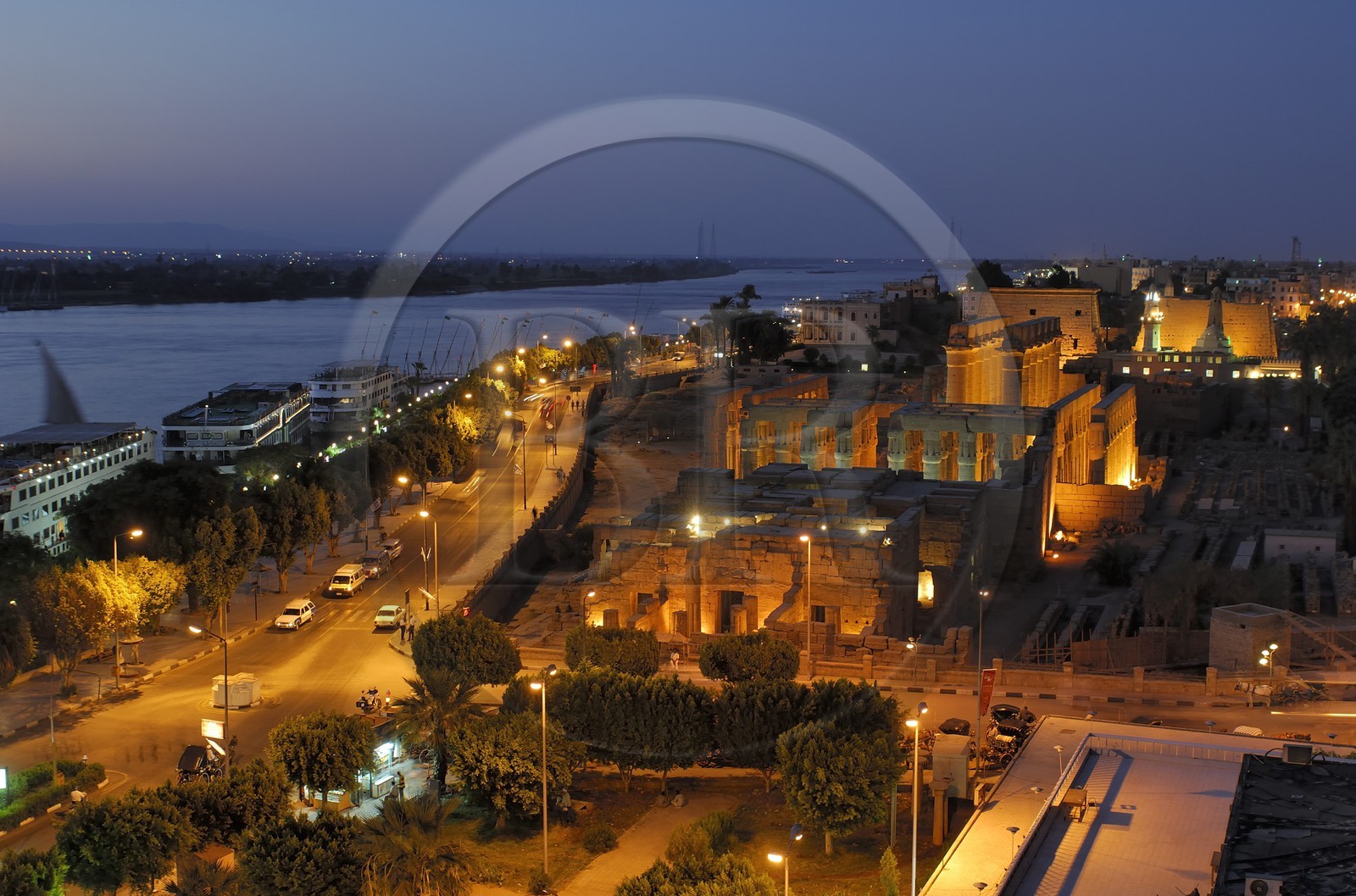 Egypt, Upper Egypt, Nile Valley, Luxor Temple at dusk, listed as World Heritage by UNESCO and the corniche road along the Nile