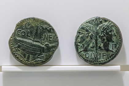 France, Gard (30), Nîmes, Musée de la Romanité, pièce de monnaie en bronze Dupondius dit As de Nimes vers 10-15 après J.-C., avec au droit les profils d’Agrippa et de Tibère et au revers le crocodile enchaîné à la palme