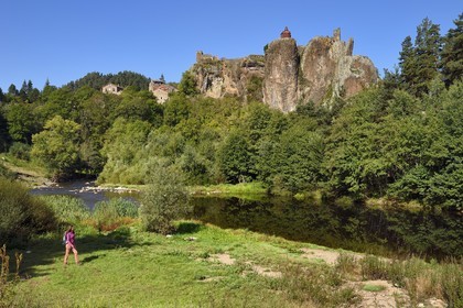 France, Haute-Loire (43), vallée de la Loire, Arlempdes, labellisé les Plus beaux villages de France, ruines du chateau perché sur un rocher basaltique (dyke volcanique) qui surplombe un méandre de la Loire que longe une randonneuse
