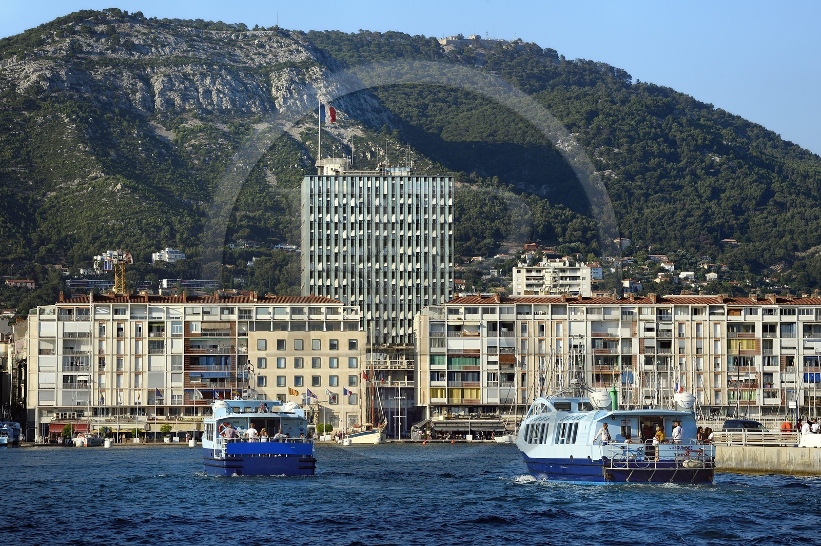 France, Var (83), Toulon, bateau-bus entrant au Port, barres d'immeubles conçues par De Mailly suite aux bombardements de 1944, l'immeuble de l'Hotel de Ville en arrière plan