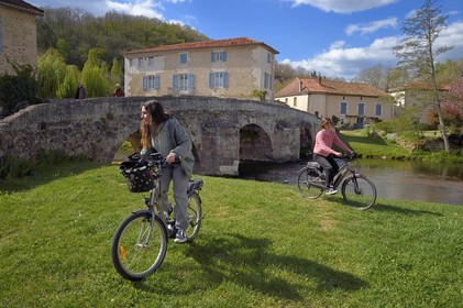 France, Dordogne, Périgord Vert, Saint Jean de Cole labelled Les Plus Beaux Villages de France (The Most Beautiful Villages of France), cyclists doing the Flow Vélo in front of the medieval bridge of the 12th century