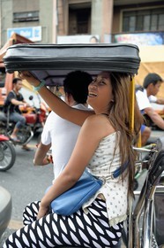 Philippines, province de Nueva Ecija, Bambang, femme à l'arrière d'un tricycle moto-taxi dans la rue principale