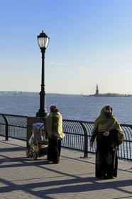 Etats-Unis, New York, Manhattan, pointe Sud, femmes voilée en promenade sur Battery Park et la Statue de la Liberté en arrière plan