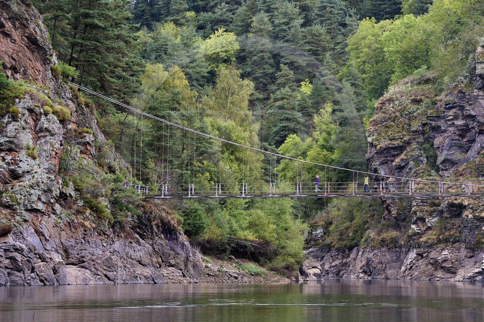 France, Cantal (15), Gorges de la Truyère, Chaliers, deux randonneuses franchissent la passerelle de Valadour au dessus de la rivière Truyère