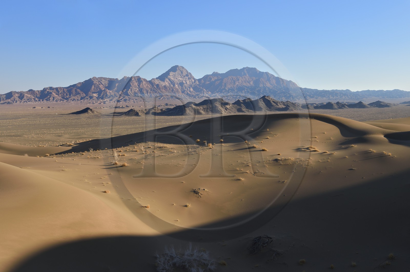 Iran, Province de Yazd, désert du Dasht-e Kavir, Moghestan, le massif montagneux de Moghestan face aux dunes dont la plus haute atteint les 200 mètres