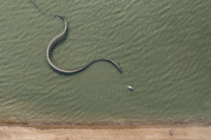 Saint-Brevin-les-Pins, Mindin, collection d'art contemporain à ciel ouvert Estuaire, le Serpent d'Océan réalisé par l'artiste chinois Huang Yong Ping représentant un long squelette de serpent de mer, installé sur l'estran et apparaissant au rythme des marées (vue aérienne)