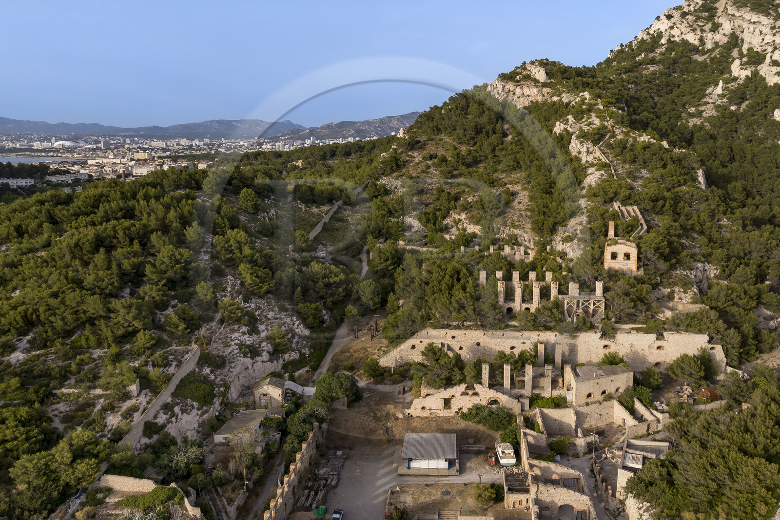 France, Bouches-du-Rhône (13), Marseille, quartier des Goudes, La Friche de l'Escalette dans les ruines d’une ancienne usine de traitement de plombau pied du massif de Marseilleveyre et la ville de Marseille en arrière plan (vue aérienne)