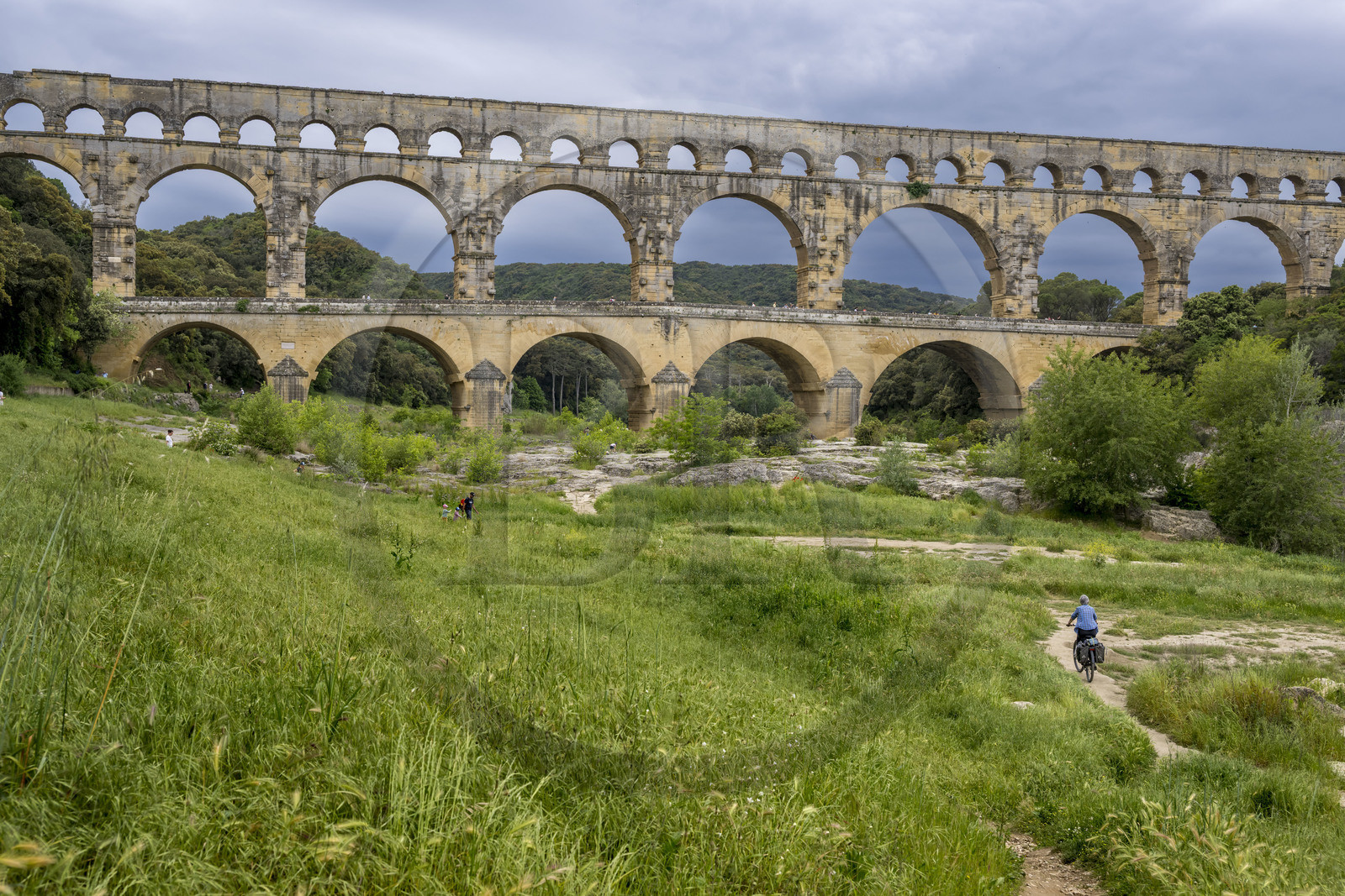 France, Gard (30), le Pont du Gard classé Patrimoine Mondial de l'UNESCO, Grand Site de France, cycliste arrivant au pont aqueduc romain qui enjambe le Gardon