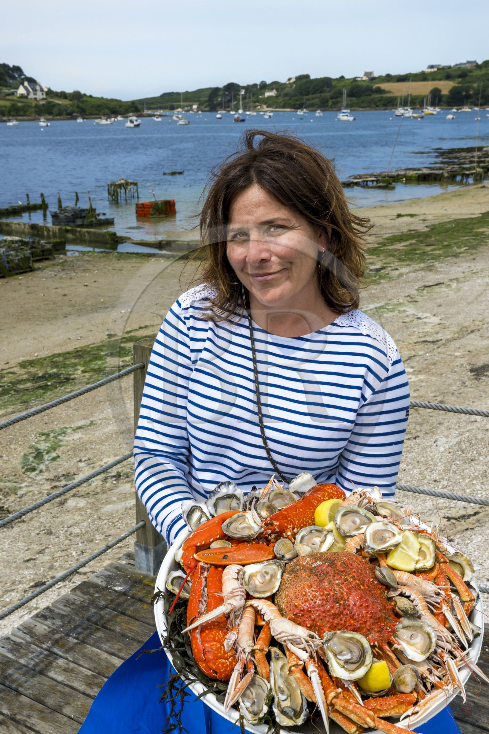 France, Finistère (29), Pays des Abers,  Lannilis, viviers et parc à huitres Prat-Ar-Coum, entreprise ostréicole de la famille d’Yvon Madec sur l'Aber Benoit, Caroline Madec propose un plateau de fruits de mer