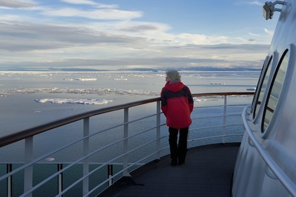 Groenland, cote Nord-Ouest, Smith sound au nord de la baie de Baffin, le bateau de croisière MS Fram de la compagnie Hurtigruten, passager observant la banquise et la côte canadienne de l'ile d'Ellesmere en arrière plan
