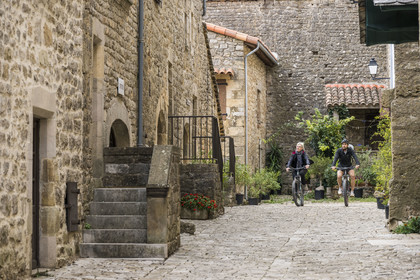 France, Aveyron, Grands Causses regional natural park, cyclists on the Brebis'Cyclette tourist cycle route in the Roquefort region, the Cistercian fort of Saint-Jean-d’Alcas