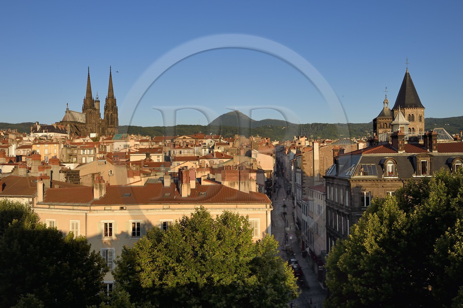 France, Puy-de-Dôme (63), Clermont-Ferrand, la rue du Port entre la cathédrale Notre-Dame de l'Assomption à gauche et la basilique Notre-Dame-du-Port à droite, en arrière plan l'ancien volcan le Puy de Dome