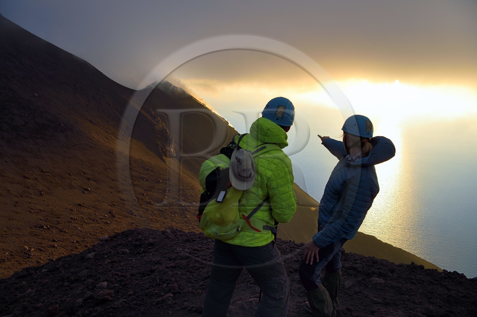 Italie, Sicile, iles Eoliennes, classées Patrimoine Mondial de l'UNESCO, ile de Stromboli, randonneurs observant les fumerolles sur les pentes du volcan actif au coucher de soleil
