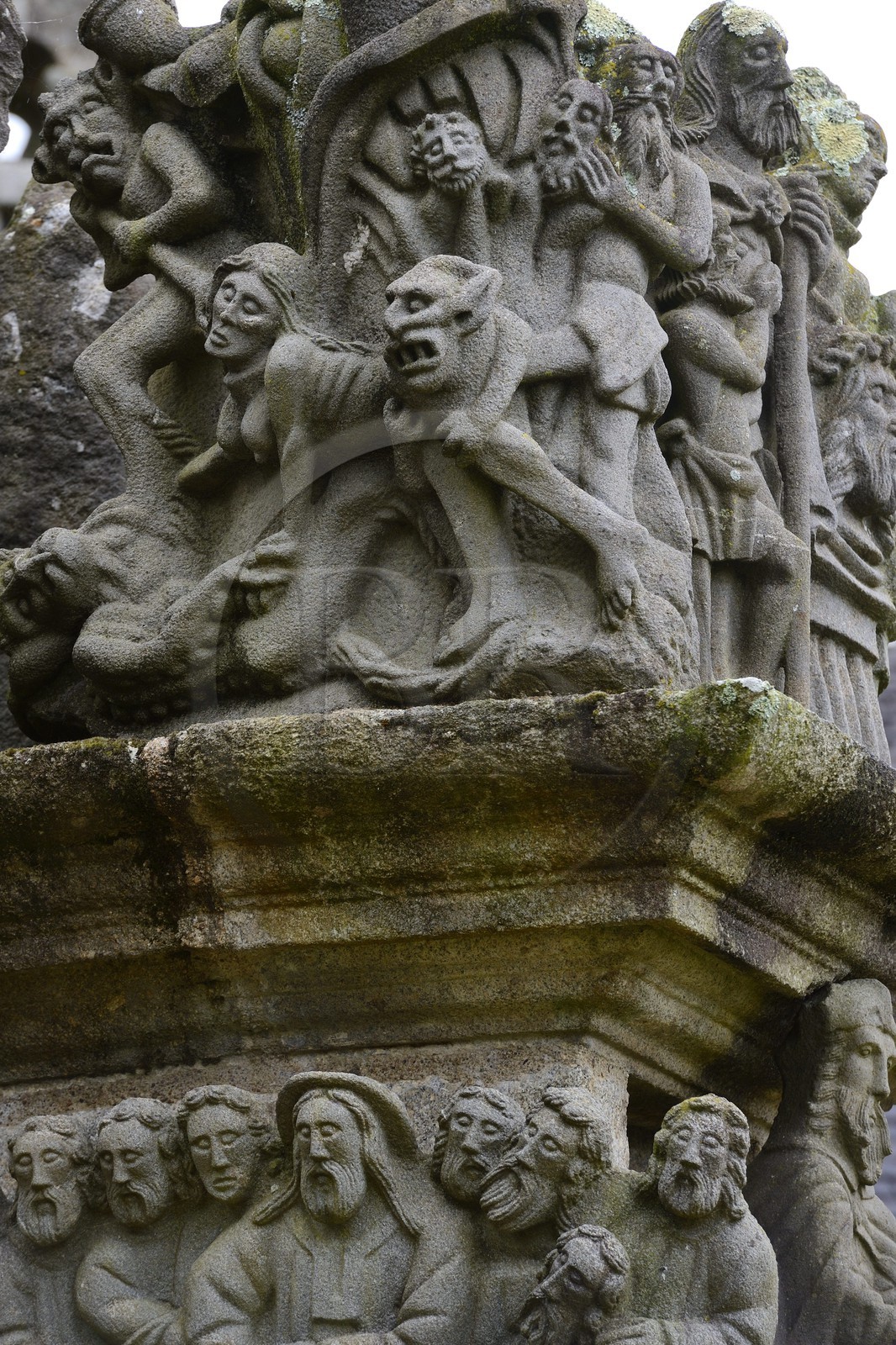 France, Finistère (29), Guimiliau, le calvaire dans l'enclos paroissial, selon la légende la jeune servante katell Gollet est vouée au flammes éternelles car elle aurait dissimulé ses écarts de conduite en confession et commis le sacrilège de dérober une hostie consacrée qu'elle a offerte à Satan qui se cachait sous les traits de son amant