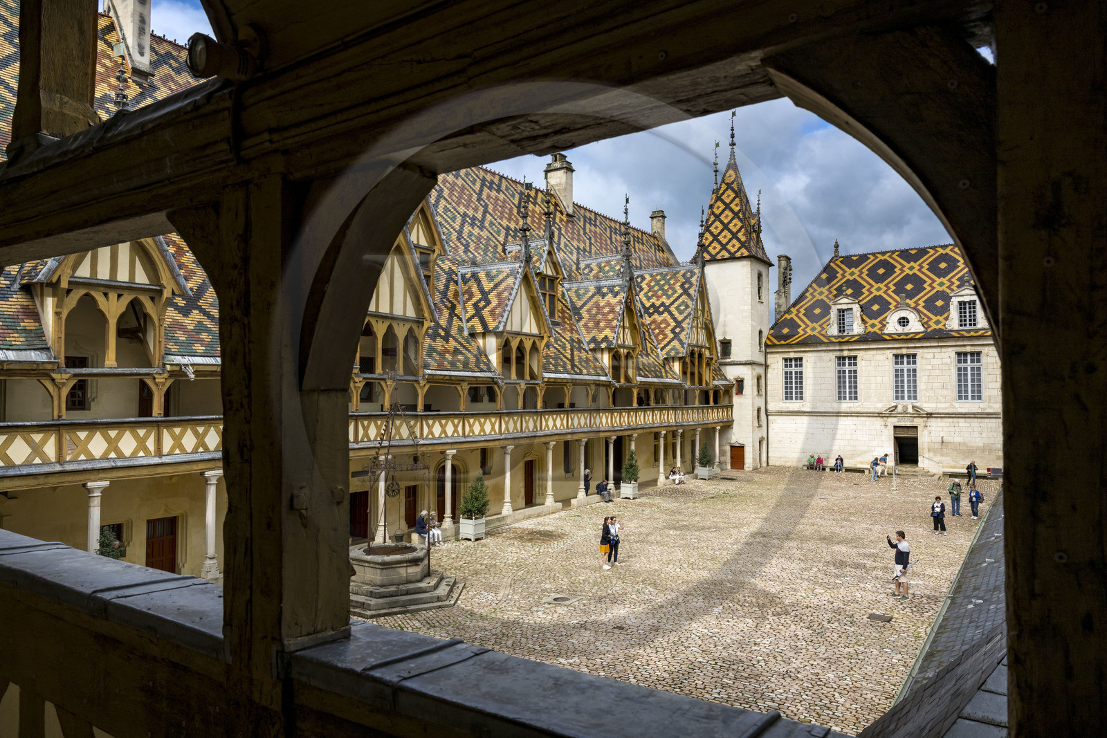 France, Cote d'Or, Beaune, area listed as World Heritage by UNESCO, Hospices de Beaune, Hotel Dieu, multi-colored glazed tile roof protecting the long arcaded gallery in the main courtyard