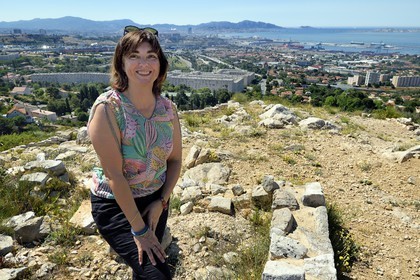 France, Bouches-du-Rhône (13), Marseille, les quartiers Nord, site archéologique celto-ligure de l'oppidum de Verduron fondé à la fin du IIIe siècle av. J.-C au premier plan, la Cité Castellane et le Grand Port Maritime en arrière plan, l'archeologue Nathalie Cazals