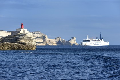 France, Corse-du-Sud (2A), Bonifacio, arrivée du ferry de liaison avec la Sardaigne au pied des falaises de calcaire et le phare à l'entrée de la calanque