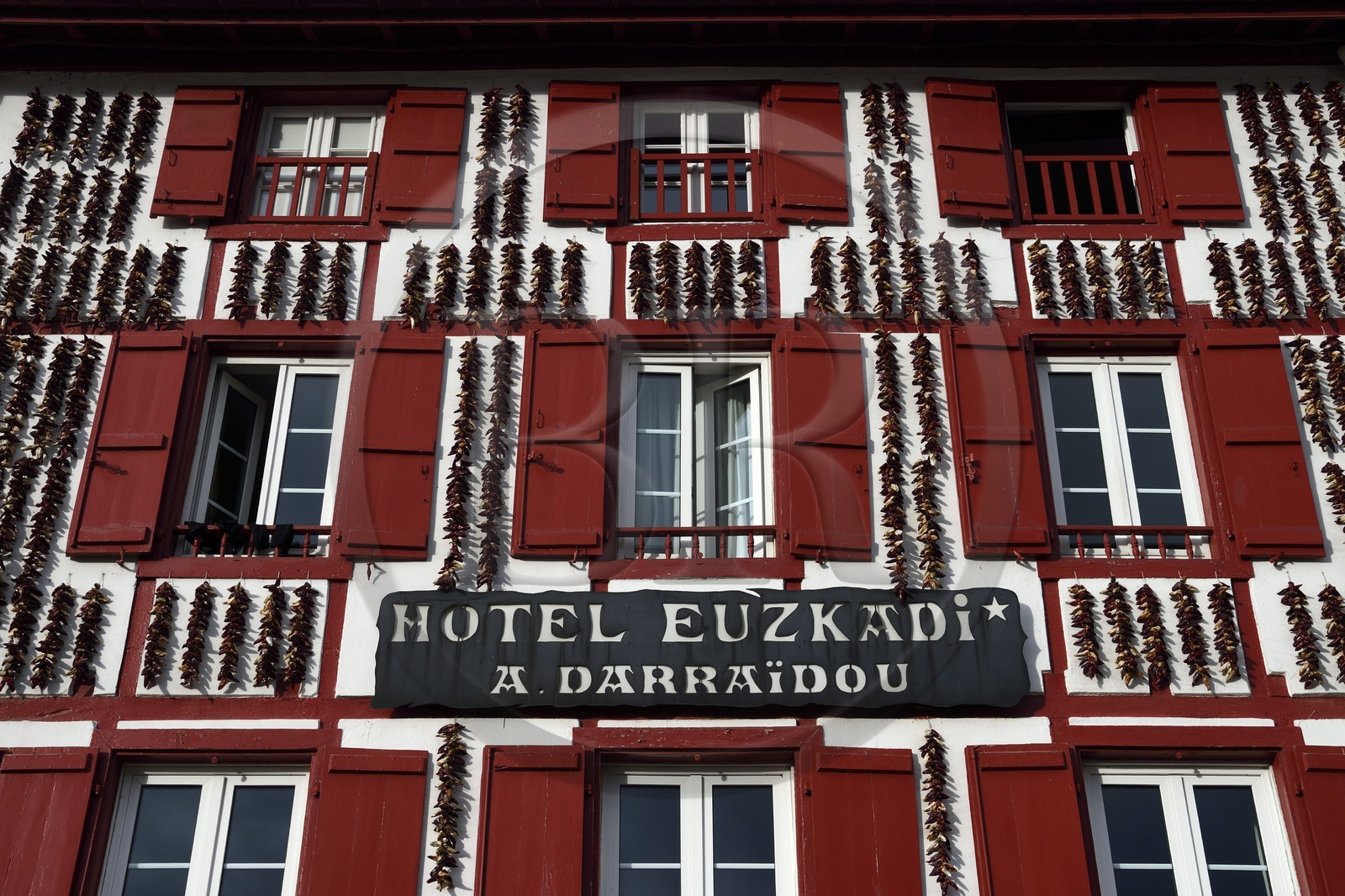 France, Pyrenees Atlantiques, Basque Country, Espelette, drying of Espelette peppers on the facades of village houses, the Euzkadi Hotel