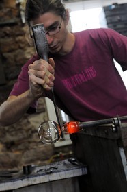 France, Moselle, Meisenthal, souffleur au Centre international d'Art verrier (CIAV), making of a christmas bowl made of glass, blowpipe put on a bench called «gamin mecanique», Thibault using his trade's cutters