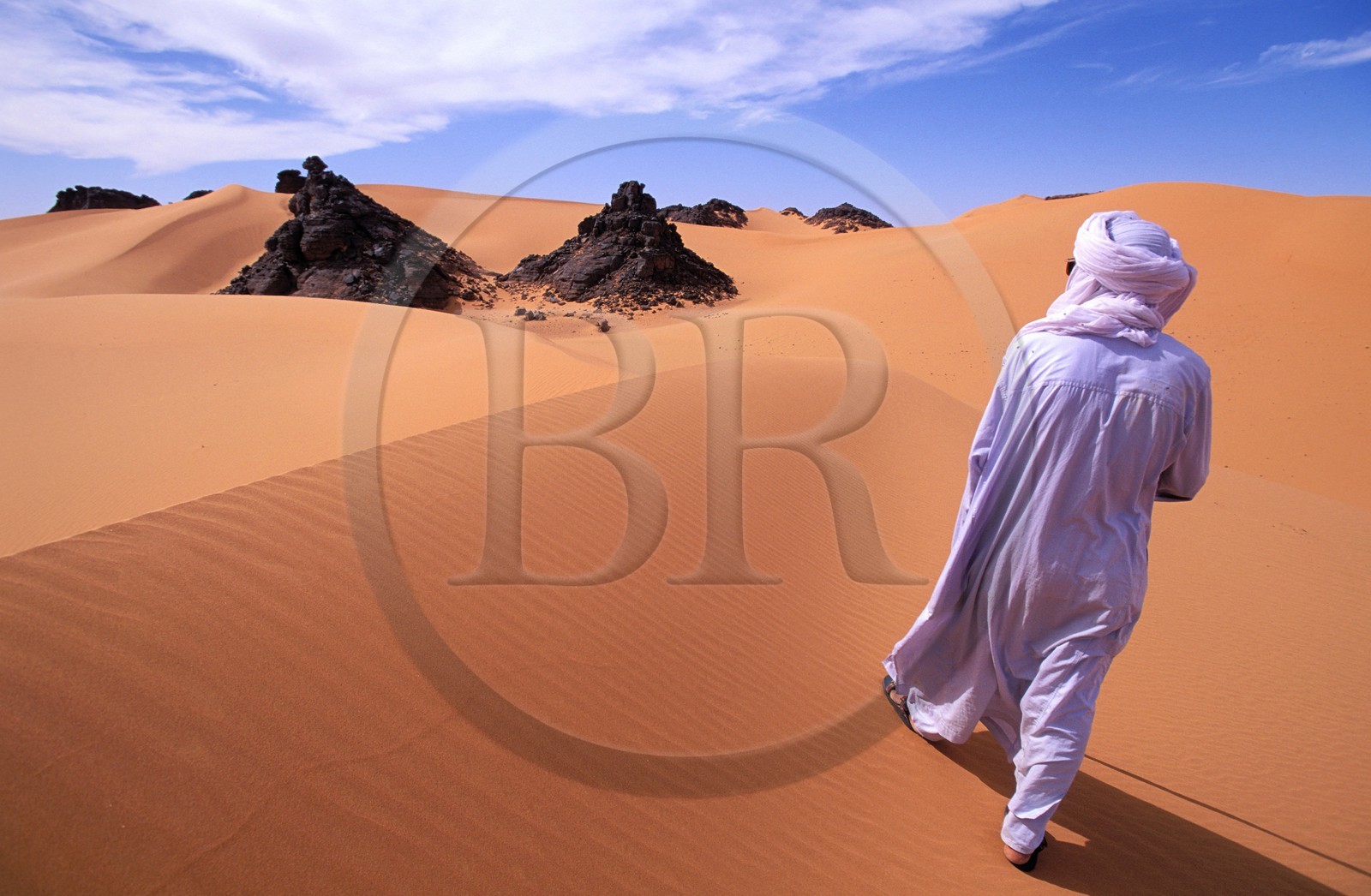 Libye, région du désert, Le Fezzan (Sahara), Touareg marchant entre les aiguilles de grès du Tassili de Maghidet (frontière algérienne)