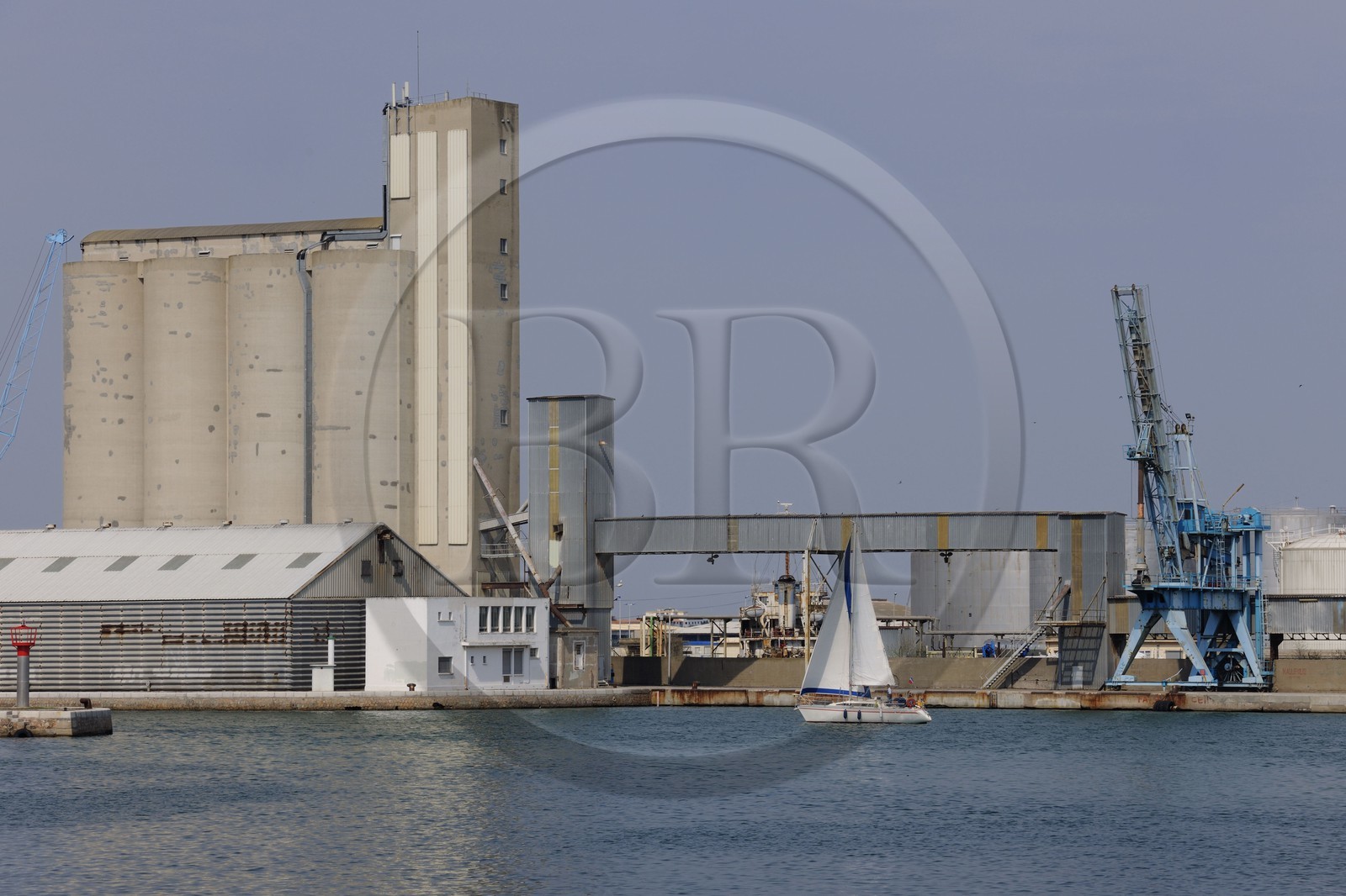 France, Herault, Sete, sailboat in front of a grain silo in the industrial and commercial port